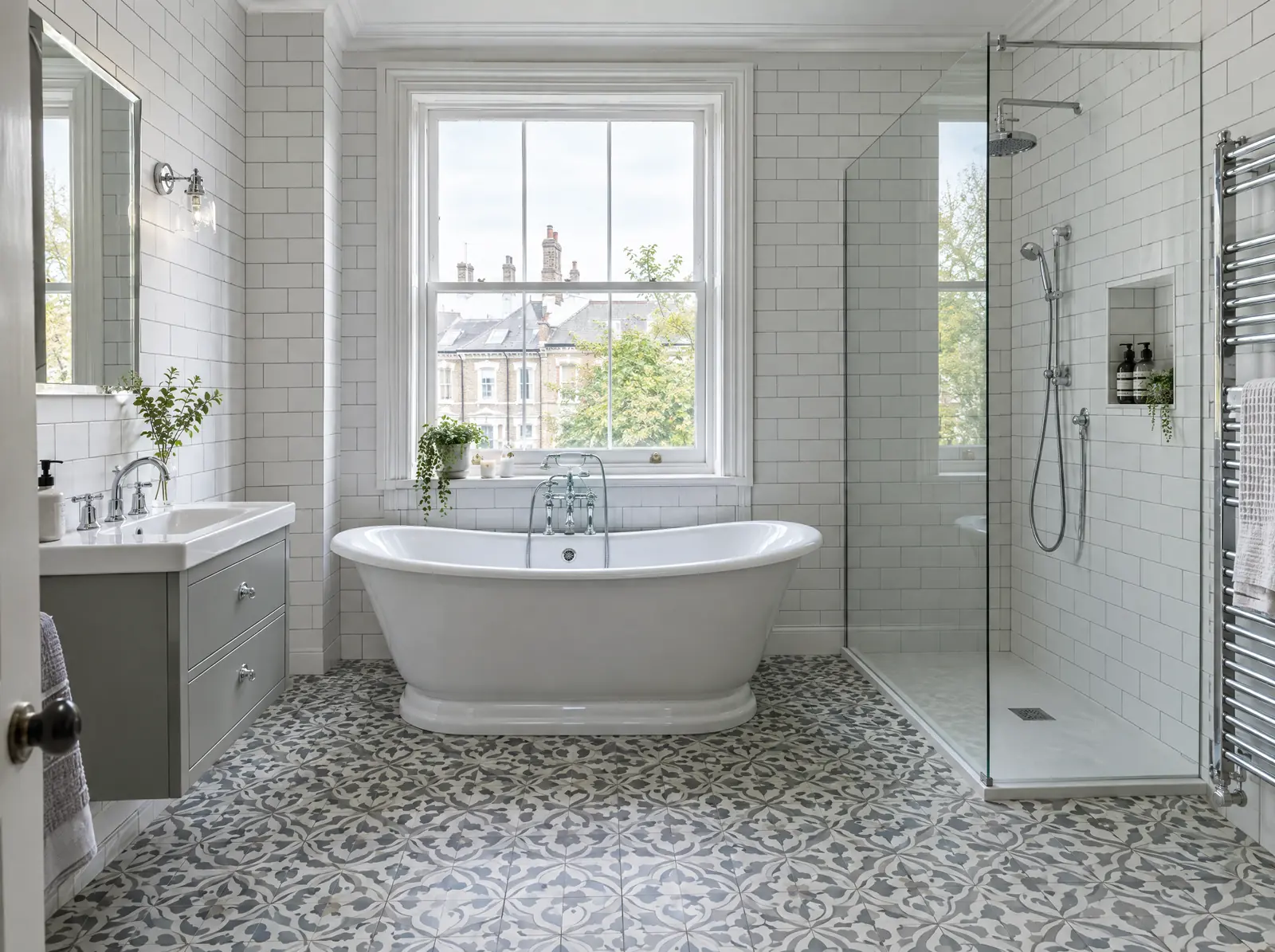 A bathroom with a roll-top bath under a sash window and patterned floor tiles