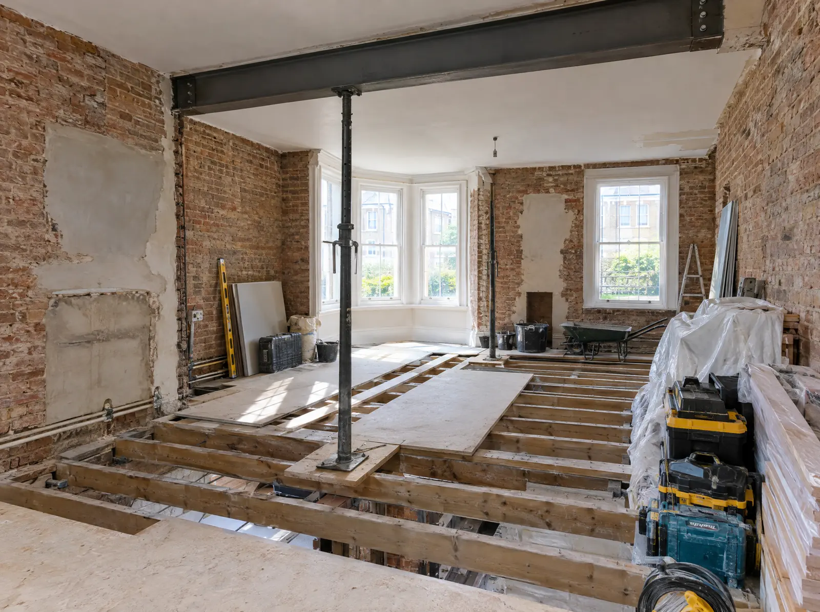 A Victorian room stripped back to brick and joists, with a new steel beam in place
