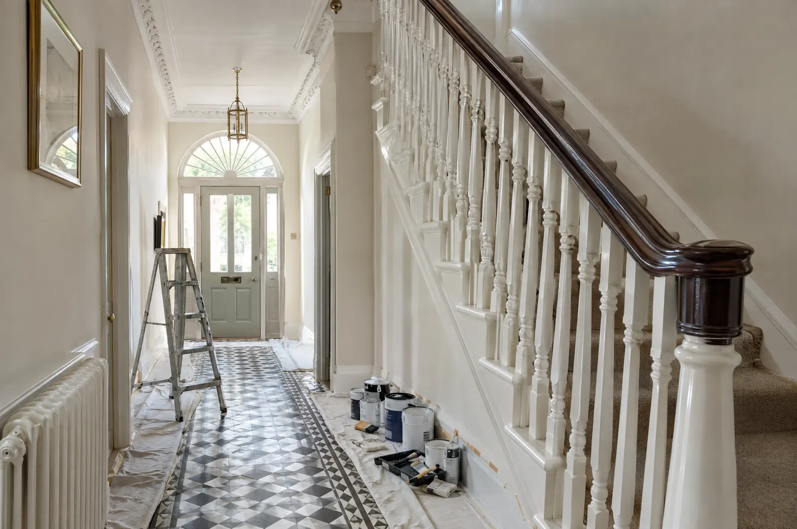 A Victorian hallway being redecorated, with dust sheets and a stepladder